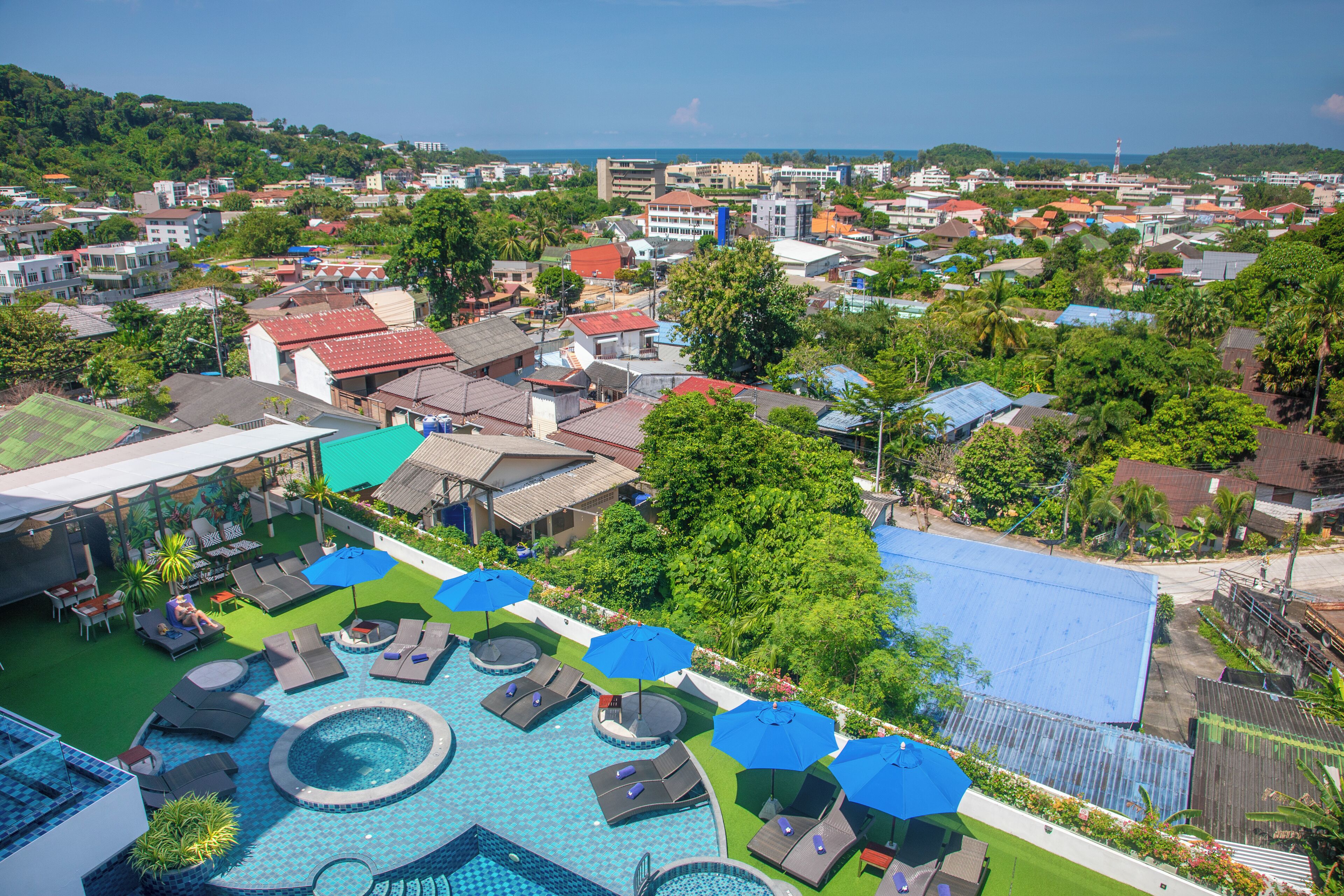 A resort with a swimming pool, sun loungers, and umbrellas.