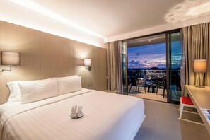 Relax in a stylish room with a large bed, city views, and a comfortable seating area.
