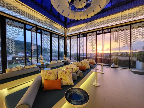 Relax in a stylish lounge with a view, featuring sofas, a round table, and decorative accents.