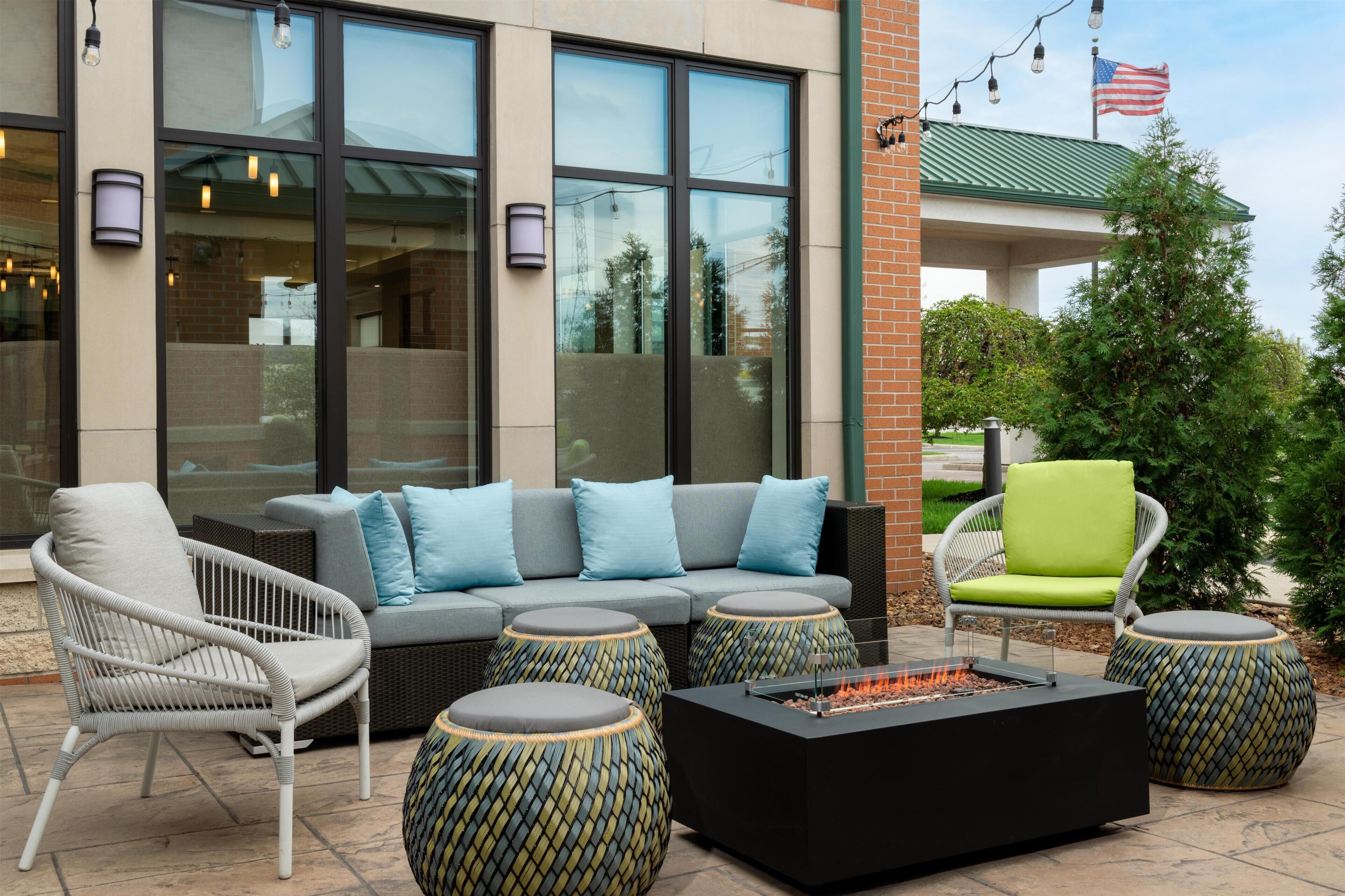 An outdoor seating area with a sofa, chairs, and a fire pit.