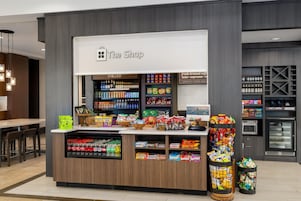 A coffee shop named 'The Shop' with a variety of snacks and beverages displayed.