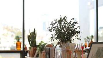 A modern room with a large window, a wooden bookshelf, and a small table.