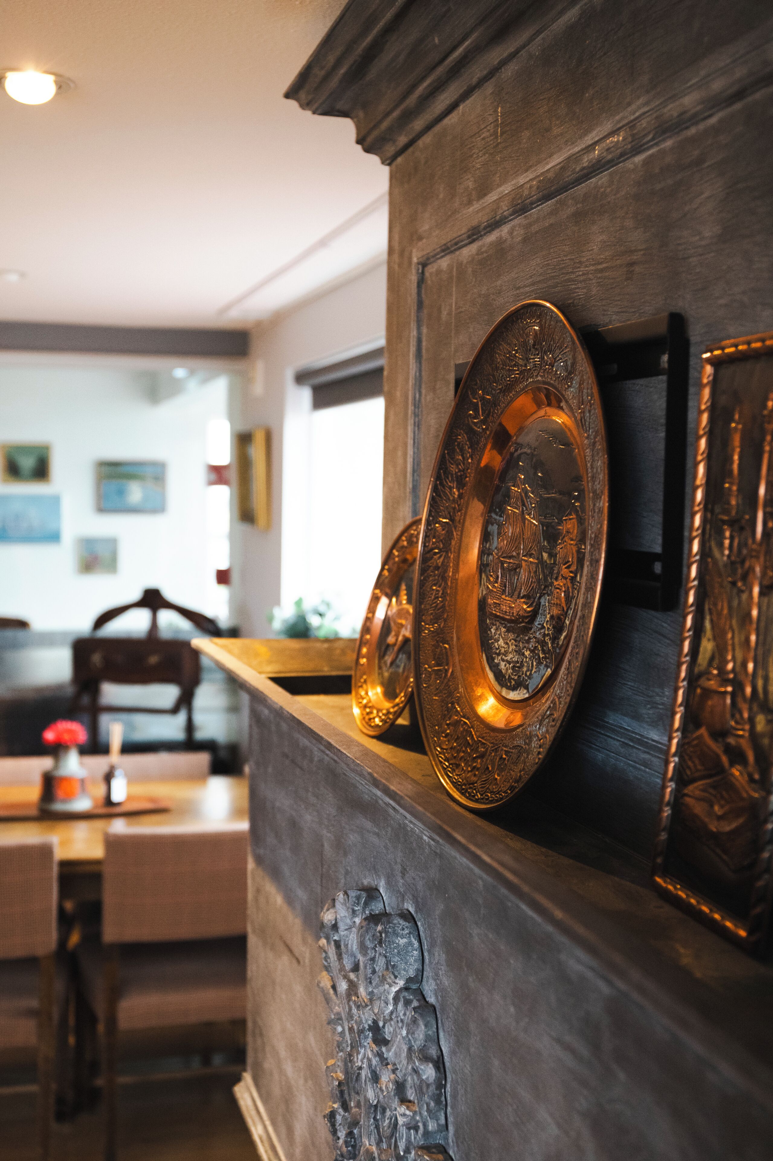 Una habitación con un aparador de madera que exhibe platos decorativos y una chimenea.