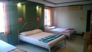 A room with two single beds, a small table, and a chair. - Phurahong Homestay (Bangkok)