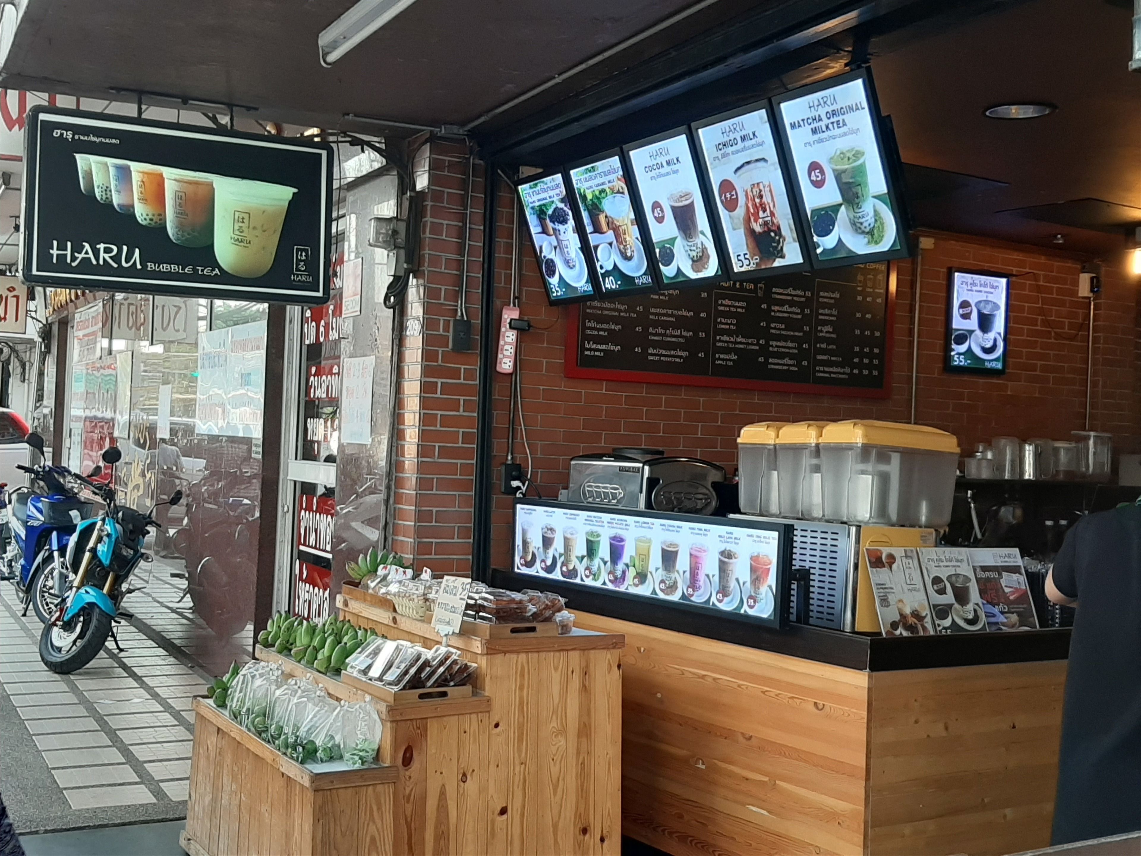 A bubble tea shop with a menu board displaying various drinks and prices.