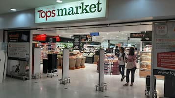 Der Eingang zum Tops Market mit einem Schild darüber und einem Blick auf den Backbereich im Inneren.