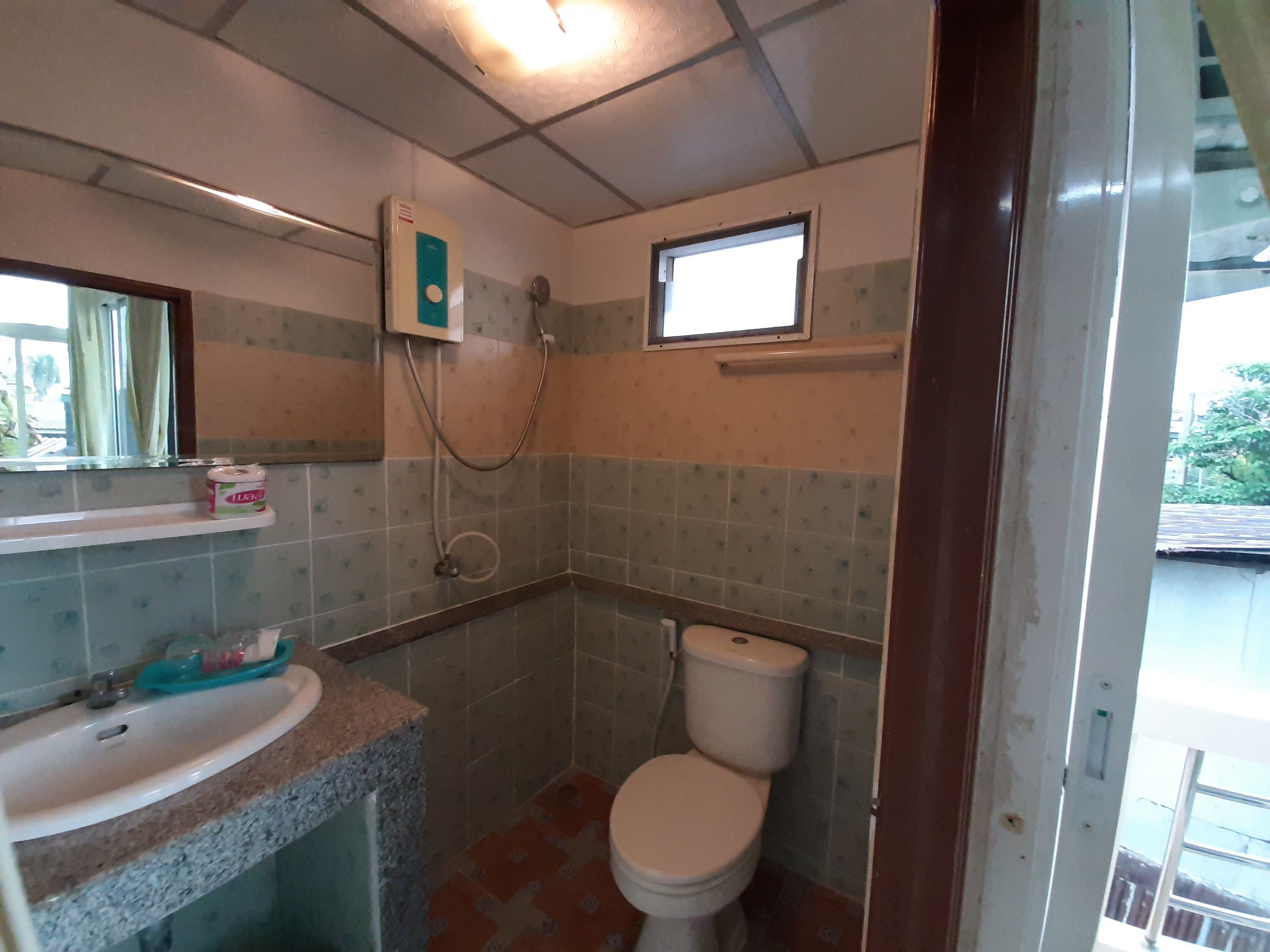 A small bathroom with a toilet, a sink, and a shower.