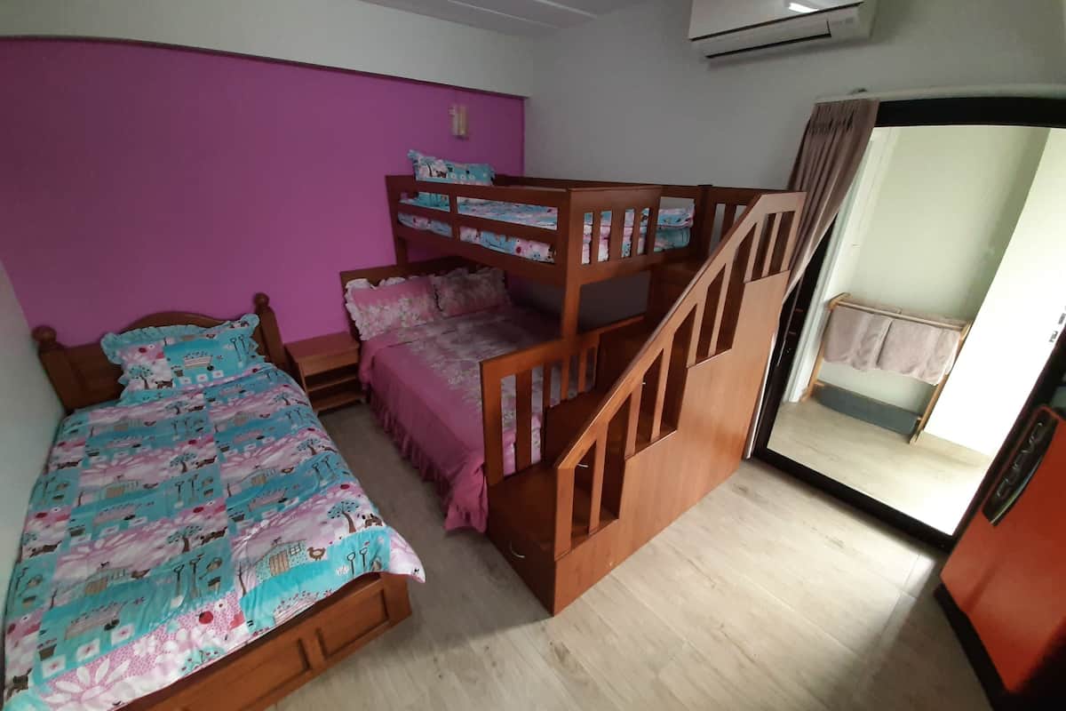 A bedroom with a bunk bed, a single bed, a wooden staircase, an air conditioning unit, and a view of the outside.