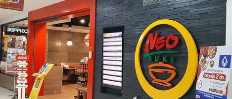 Un restaurante llamado Neo Sushi, con un letrero negro y amarillo.