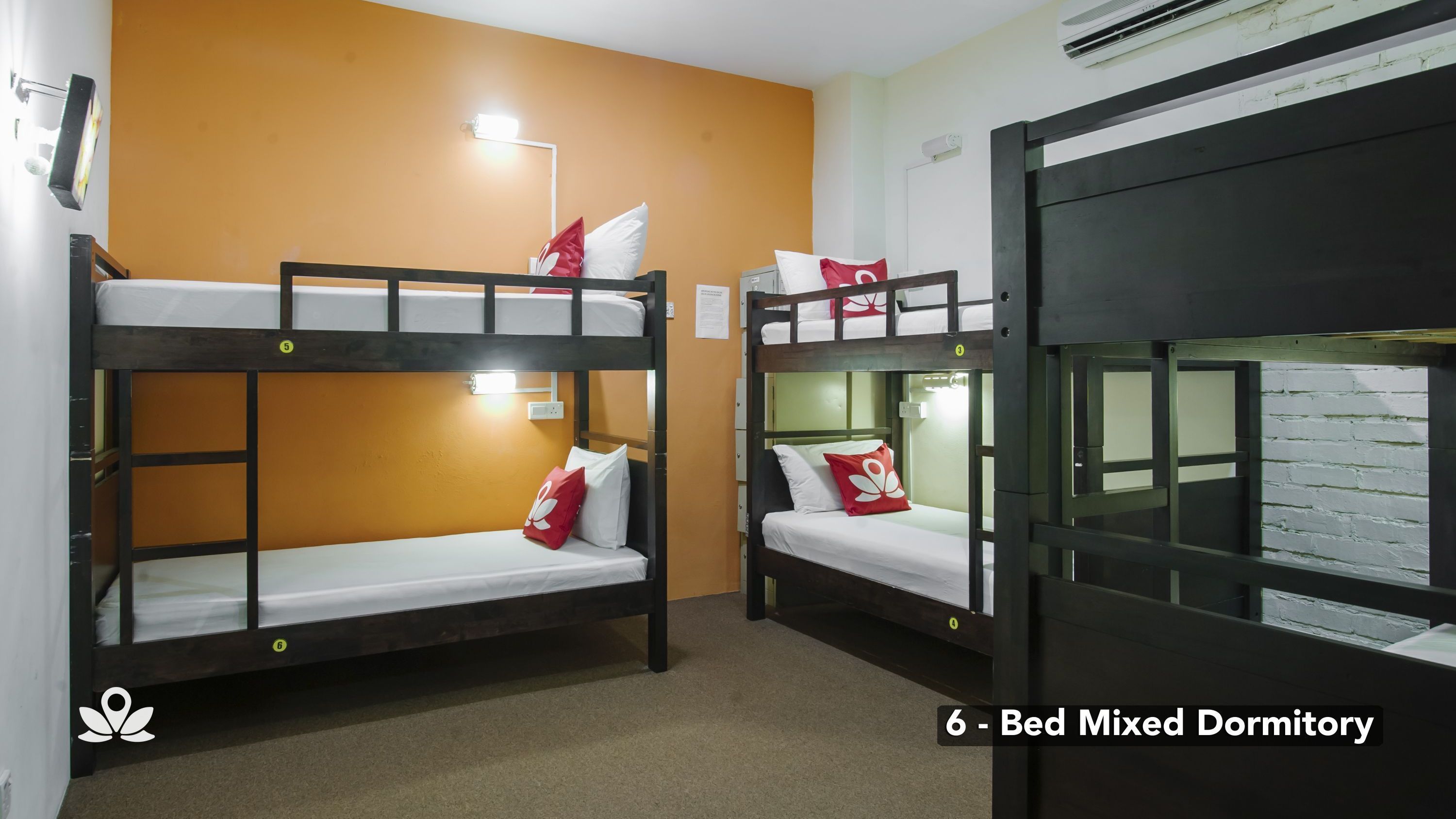 A dormitory with bunk beds, a wall-mounted air conditioner, and a light fixture.