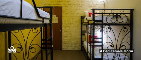 A 4-bed dormitory room with bunk beds, a brick wall, and a door.