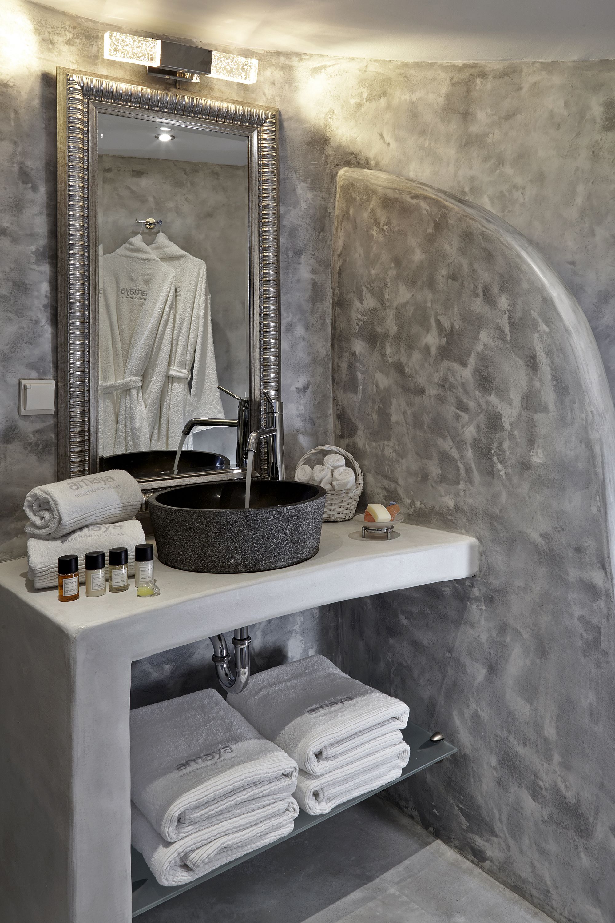 Une salle de bain avec un grand miroir, un lavabo rond et un porte-serviettes.