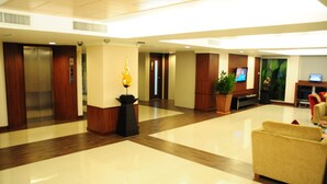 A hotel lobby with a reception desk, seating area, and an elevator. - Avion Hotel (Bangkok)