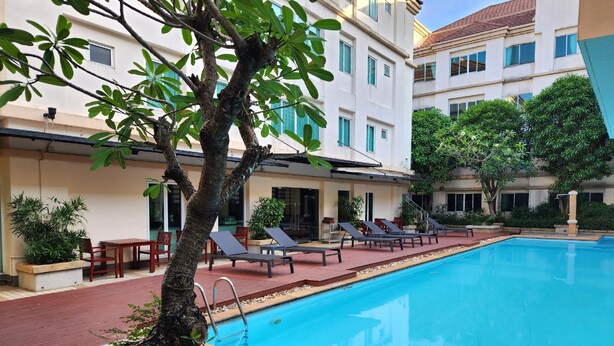A swimming pool with lounge chairs and a small garden area. - Avion Hotel (Bangkok)