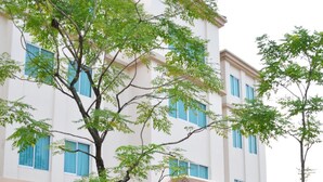 A modern building with a white facade, multiple windows, and a covered entrance. - Avion Hotel (Bangkok)