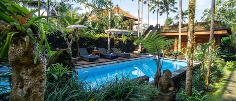 Een buitenzwembad en ligstoelen