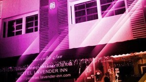 A building with a neon sign reading "Lavender Inn" and a sign indicating "RESERVE" for the hotel. - Lavender Inn Permas Jaya (Masai)