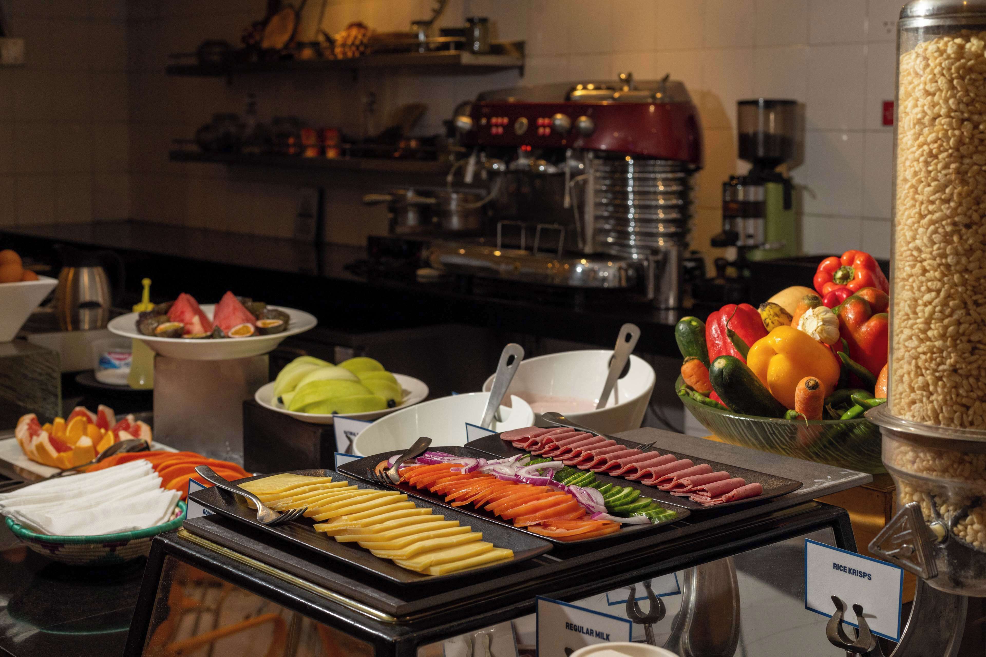 Un buffet proposant une variété de plats, notamment des fruits, des légumes et des viandes.