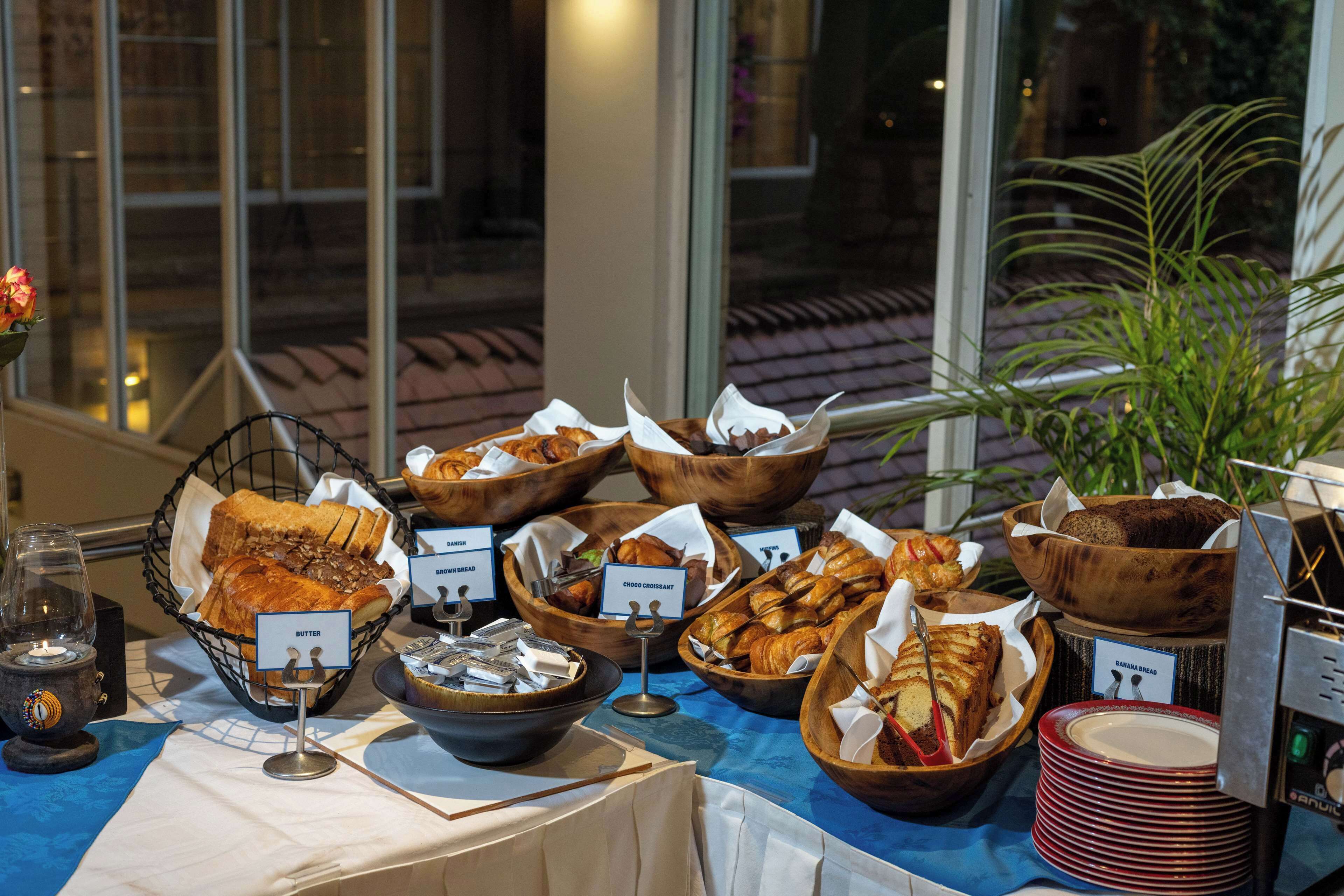 A buffet table with various baked goods and a coffee machine.