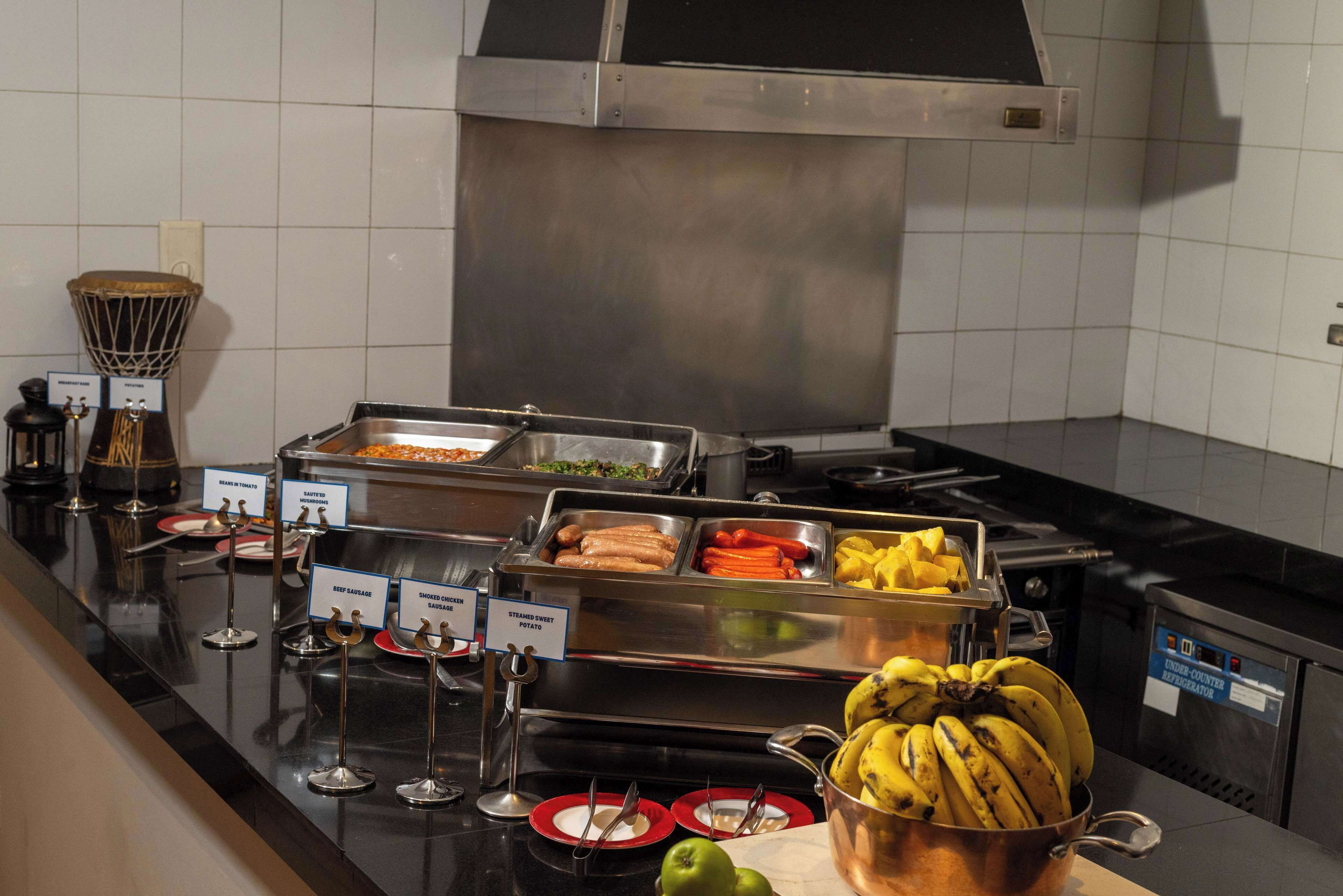 En buffé med ett varierat utbud av mat, inklusive kött, grönsaker och frukt.