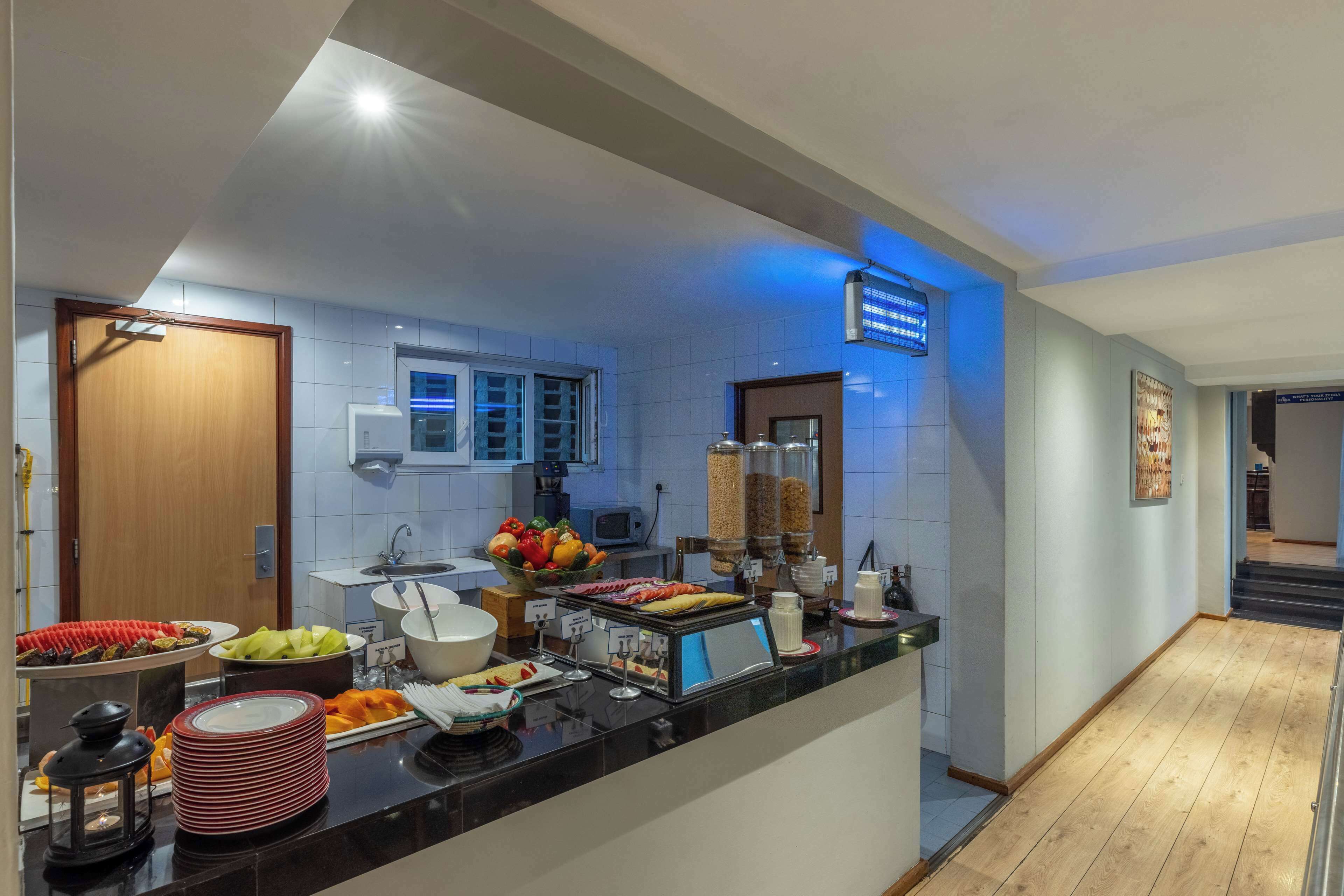 Une cuisine d’hôtel avec un buffet proposant divers plats et un espace dédié aux boissons chaudes, notamment au café.