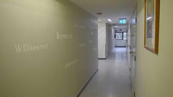 A hallway with a wall displaying 'Welcome' in multiple languages.