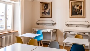 Une pièce dont le plafond est orné de motifs décoratifs, avec un lustre et deux tableaux accrochés aux murs.