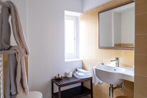 Une salle de bain équipée d’un lavabo, d’un miroir et d’un porte-serviettes.