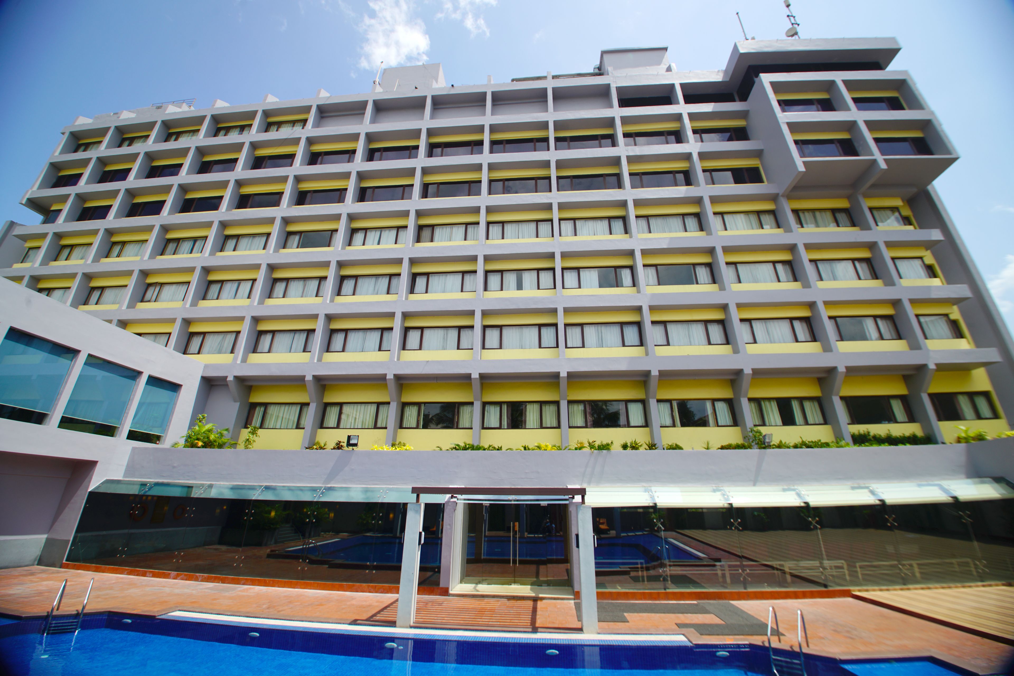 A multi-story hotel with a pool area in the foreground.