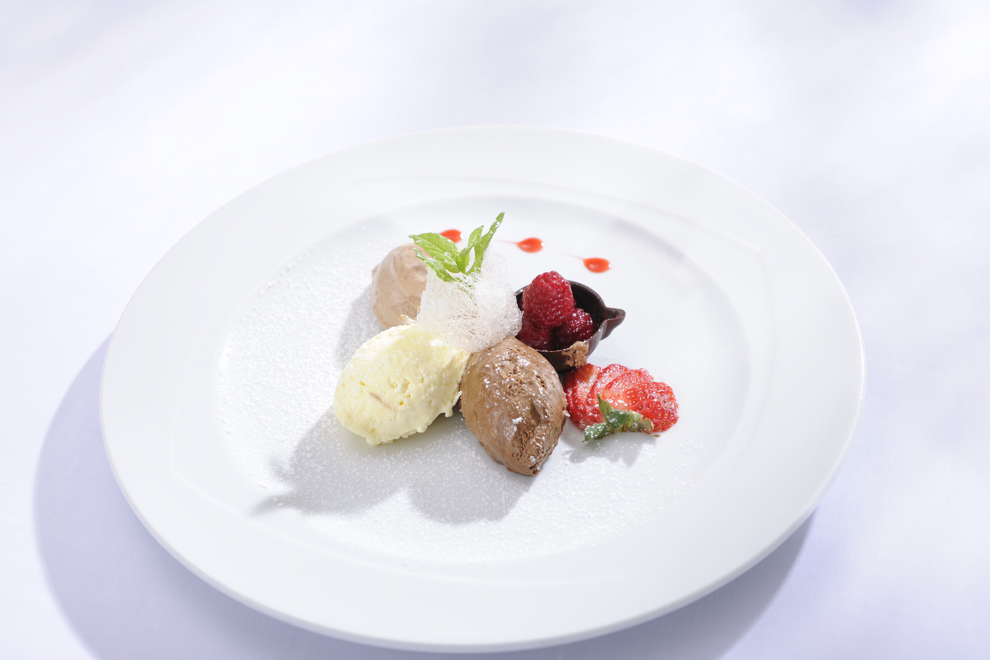 Une assiette de dessert avec de la crème glacée et des fruits rouges.
