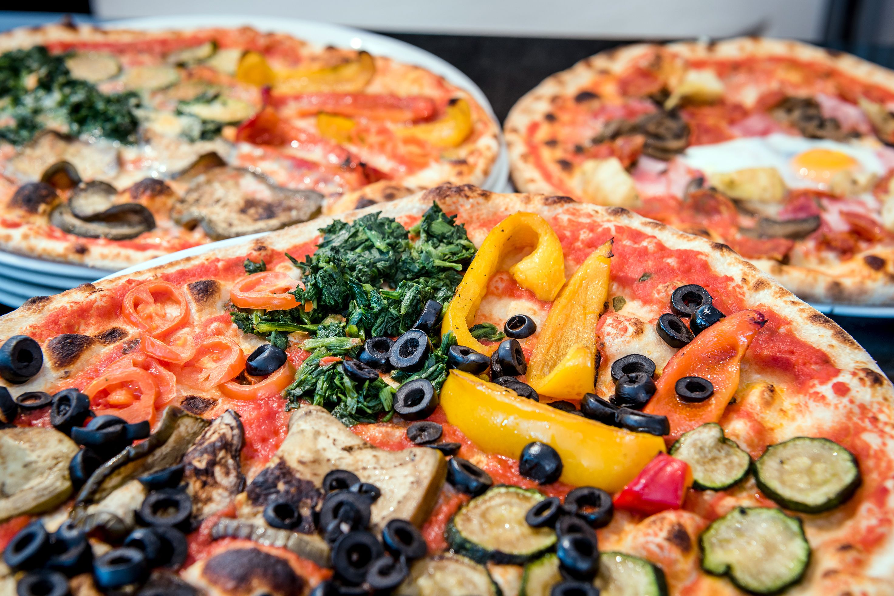 Three pizzas with various toppings.
