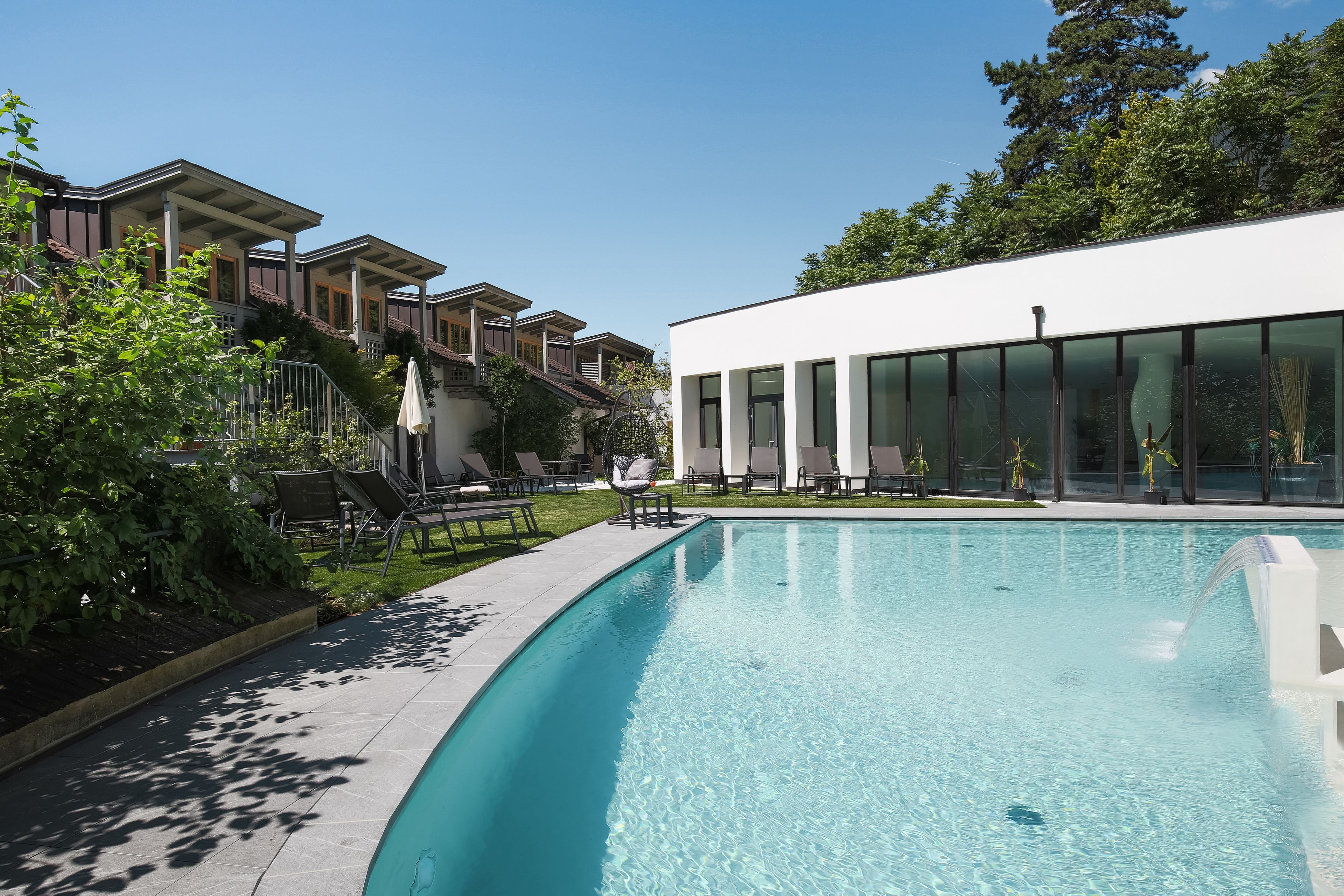 Una piscina cubierta, una piscina al aire libre de temporada, sombrillas