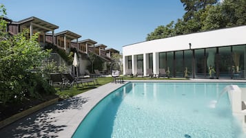 Una piscina techada, una piscina al aire libre de temporada, sombrillas