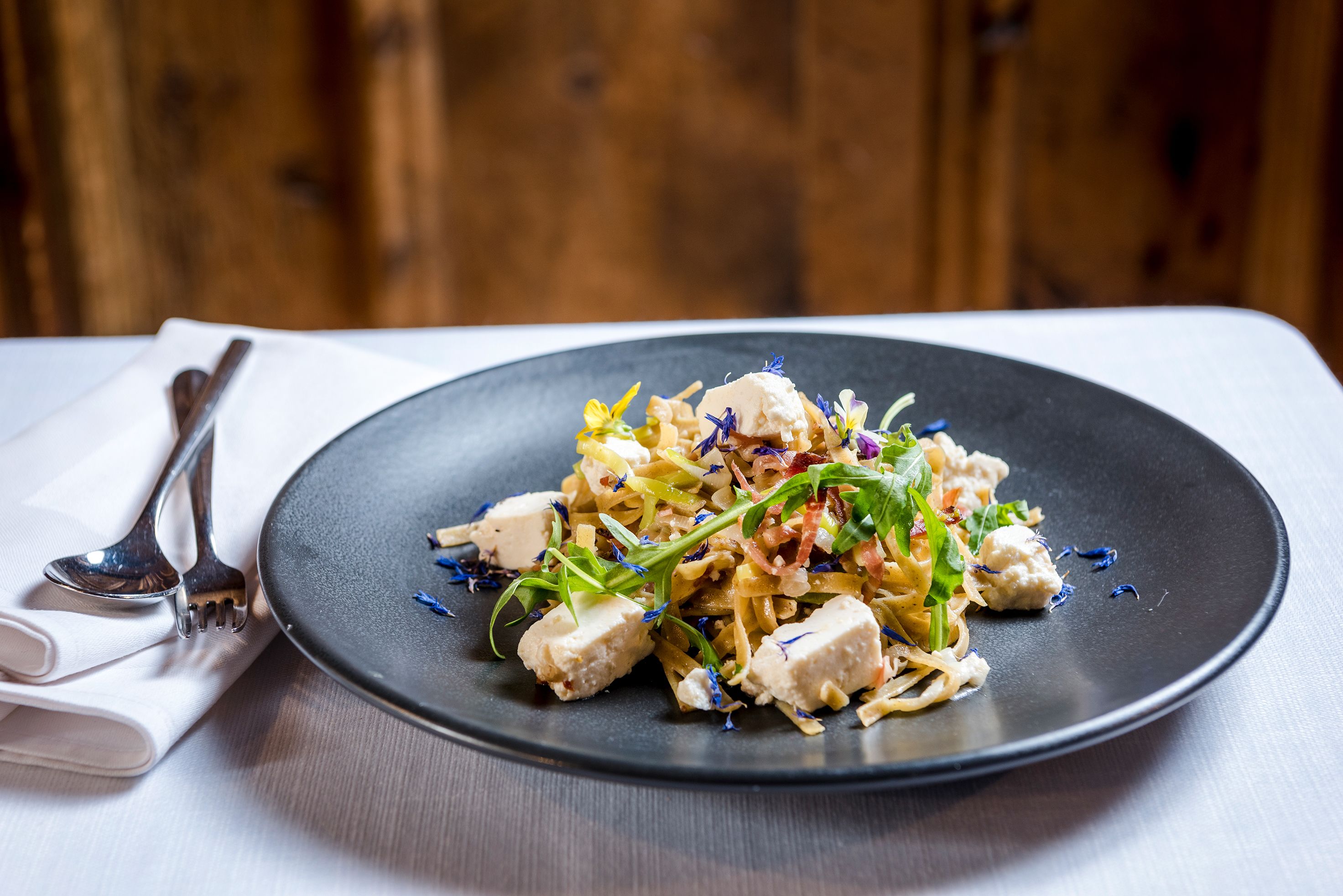 A plate of food with a fork and spoon on a table.