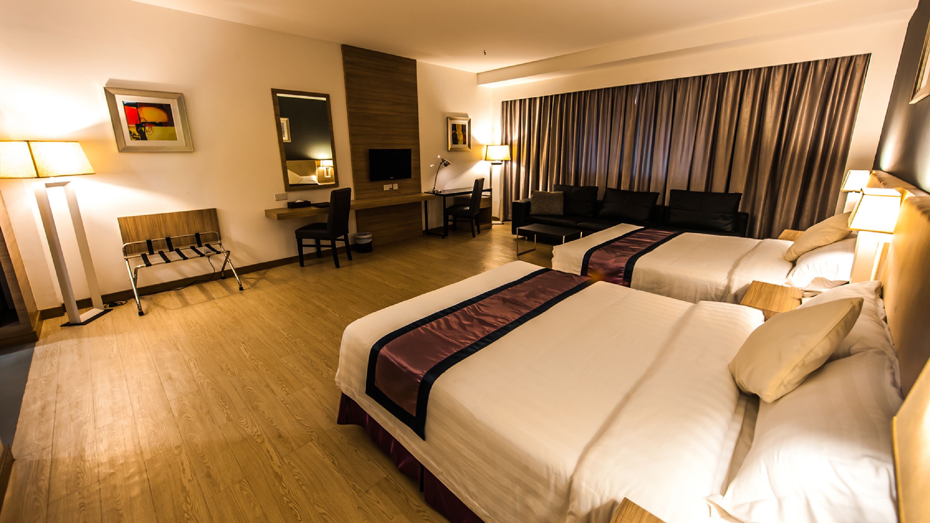 Een hotelkamer met twee bedden, een bureau, een stoel, een televisie en een badkamer.
