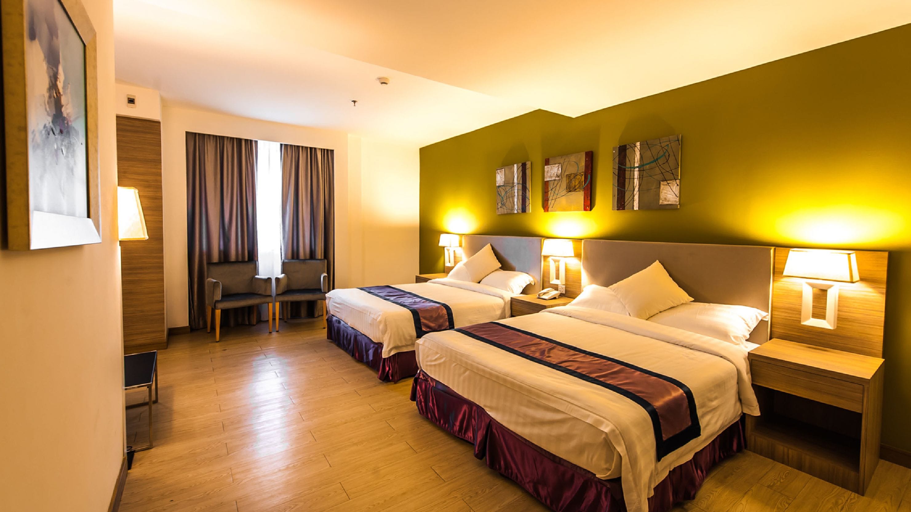 Habitación de hotel con dos camas, un escritorio y una silla.