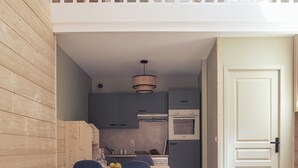 A modern apartment with a loft bedroom, a dining area, and a kitchen. - Le Clos du 5 - Appart Hotel Bagneres (Bagnères-de-Bigorre)