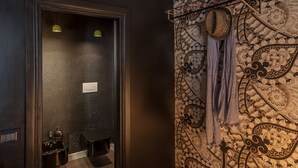 A bathroom with a patterned wall, a towel rack, and a mirror. - Frattina 57 (Rome)