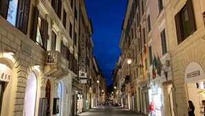 A cobblestone street lined with historic buildings, some with shopfronts and signage. - Frattina 57 (Rome)