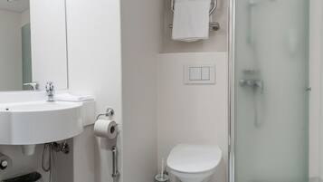 A modern bathroom with a sink, toilet, and glass-enclosed shower.