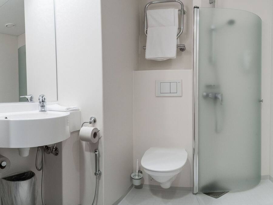 A modern bathroom with a sink, toilet, and glass-enclosed shower.