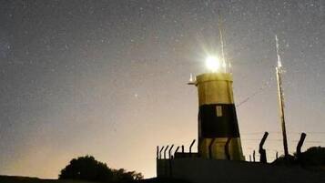 Un faro de noche bajo un cielo despejado.