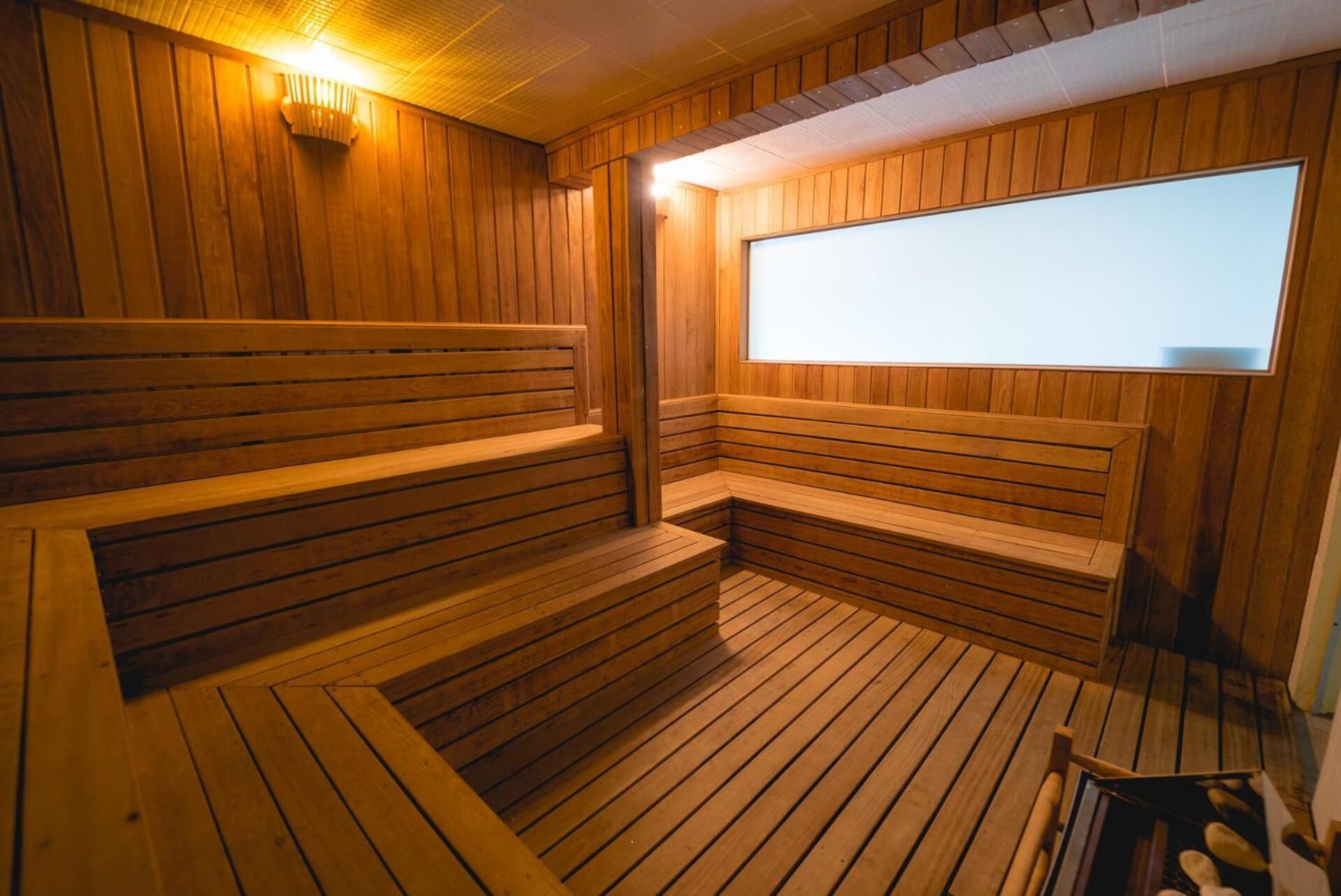 A sauna with wooden benches and a large window.