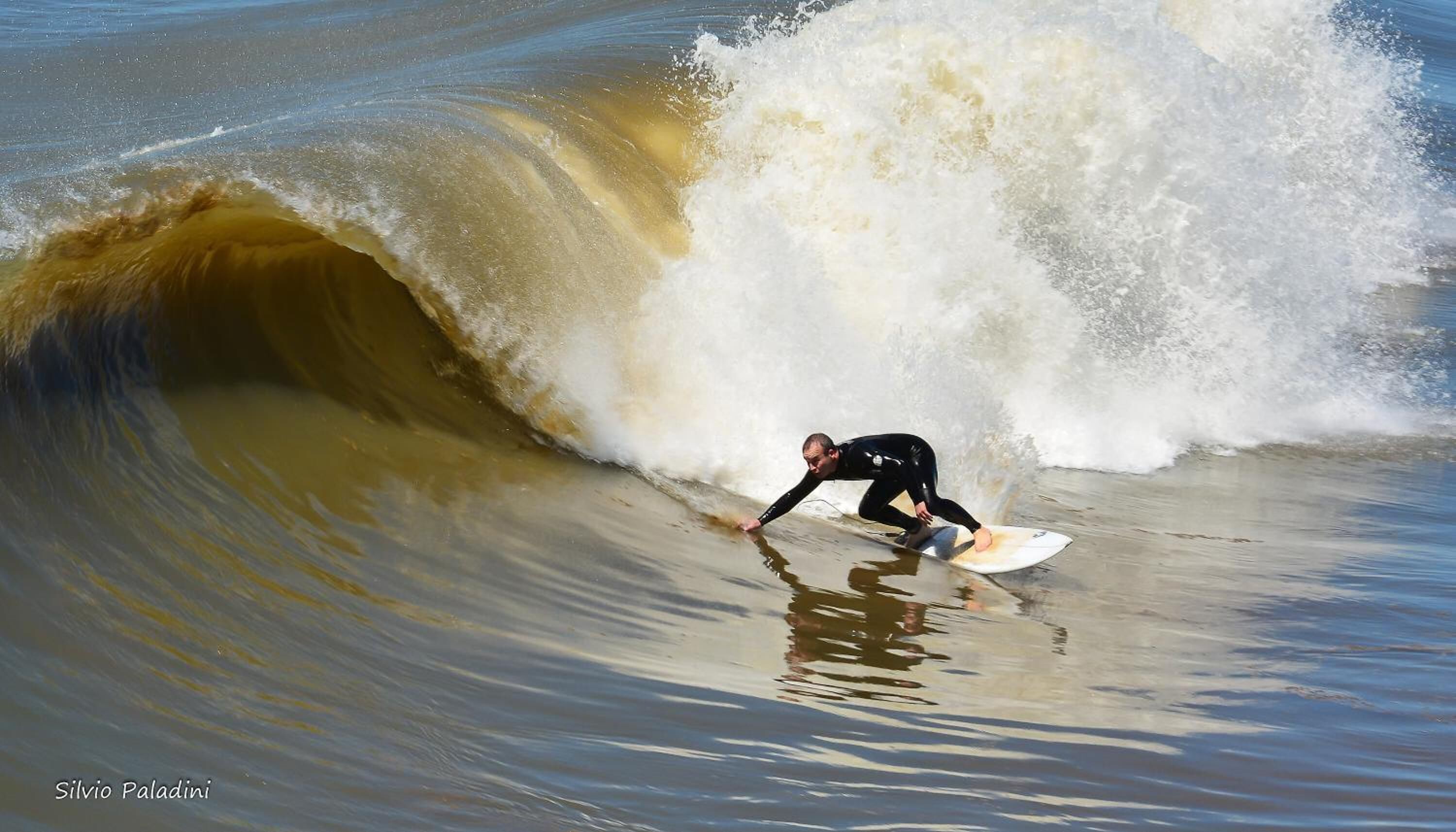 Um surfista deslizando numa onda grande.