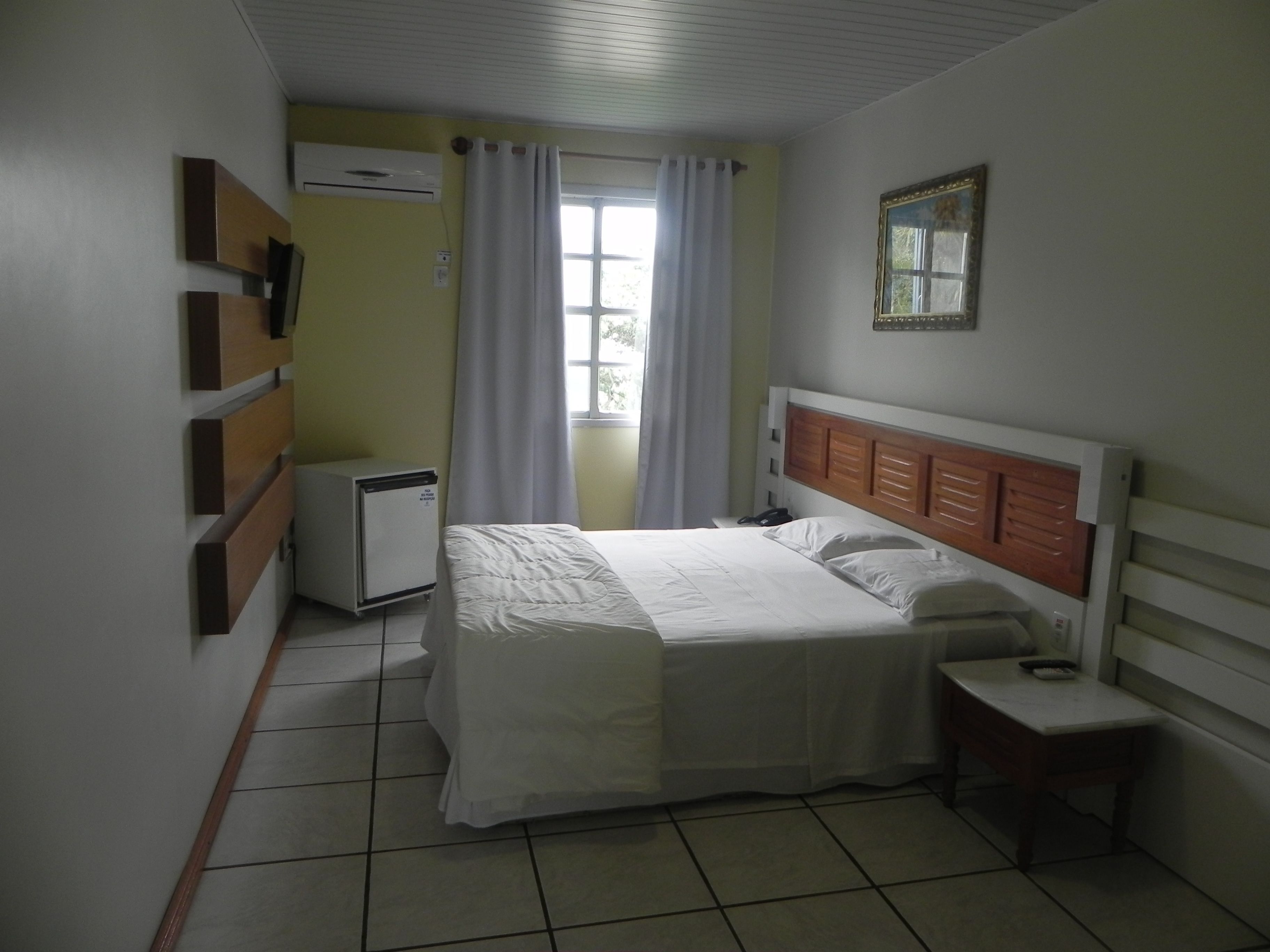 A bedroom with a bed, bedside table, and a small desk.