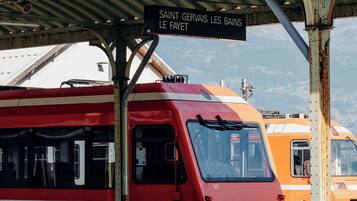A red and white train at a station with a sign reading 'SAINT GERVAIS LES BAINS LE FAYET'.