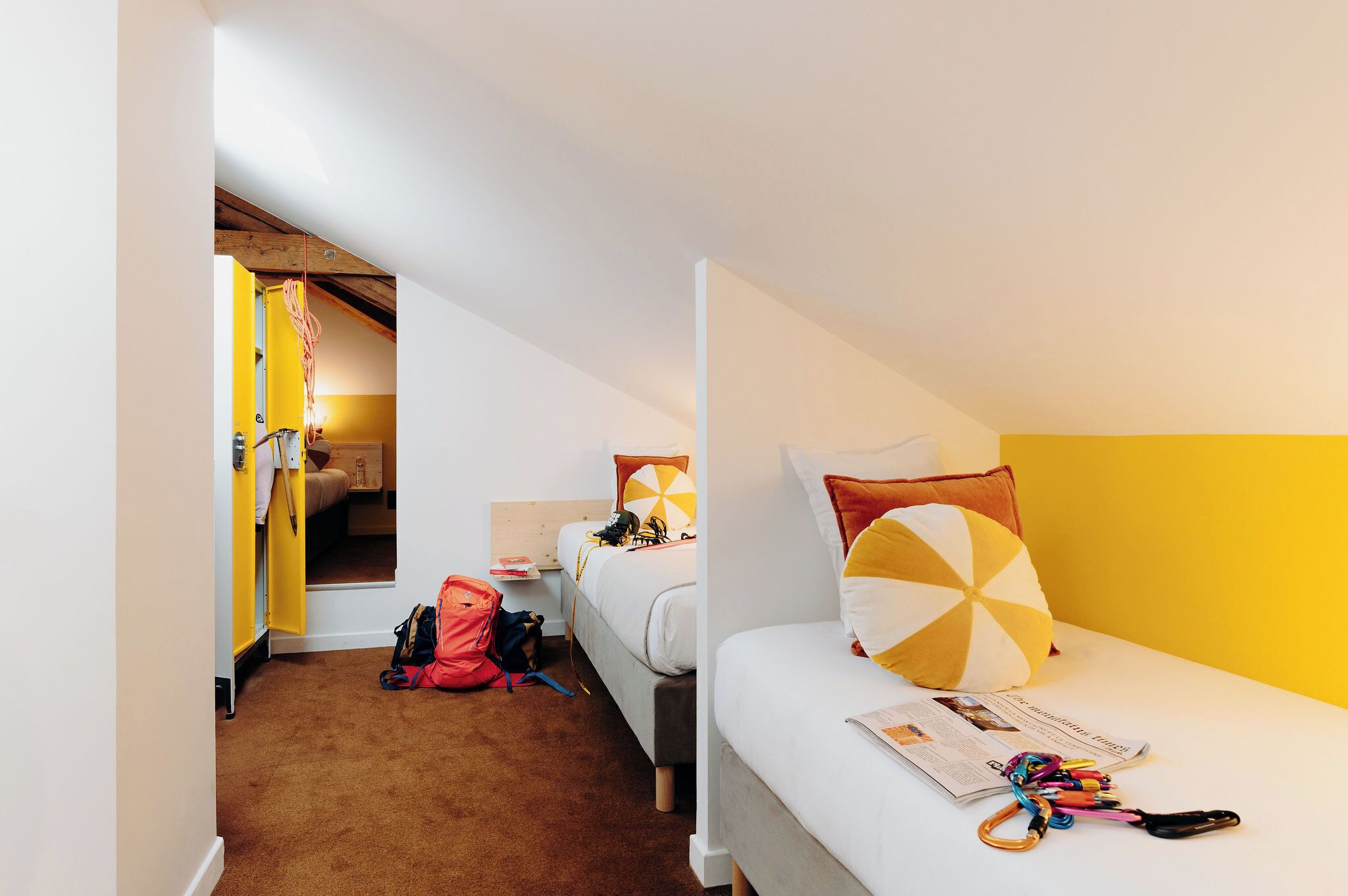 A hotel room with a single bed, a small desk, and a wardrobe.