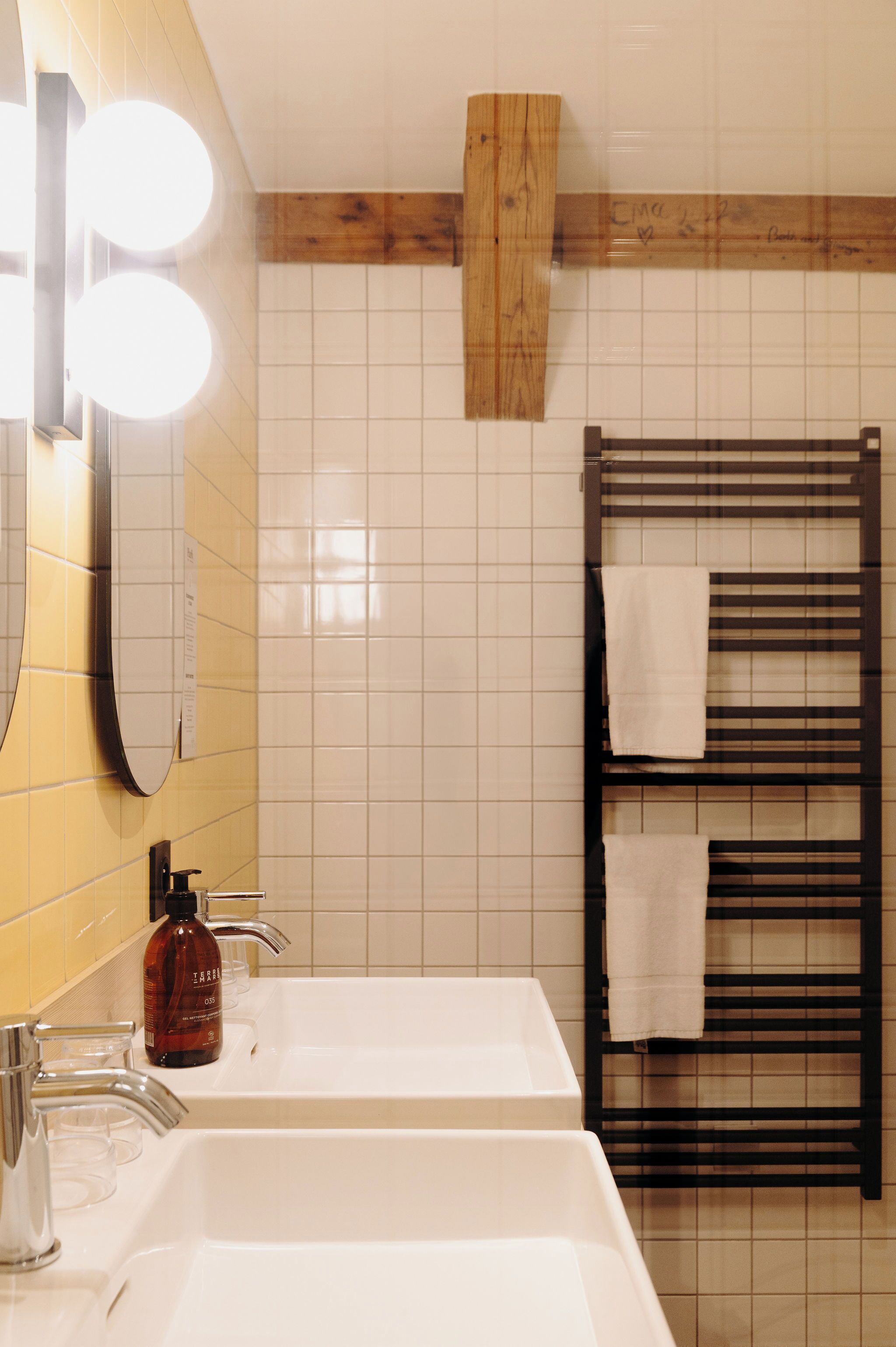 Une salle de bain avec deux lavabos, un miroir et un porte-serviettes.