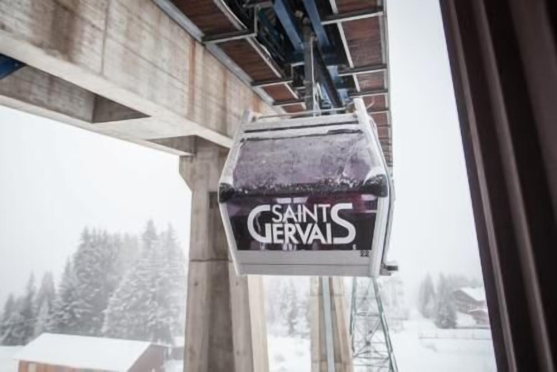 En snötäckt skylt med texten ”SAINTS GERVAIS” på en byggnad.