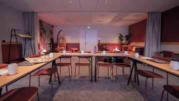A conference room with tables, chairs, and a large wall mural.